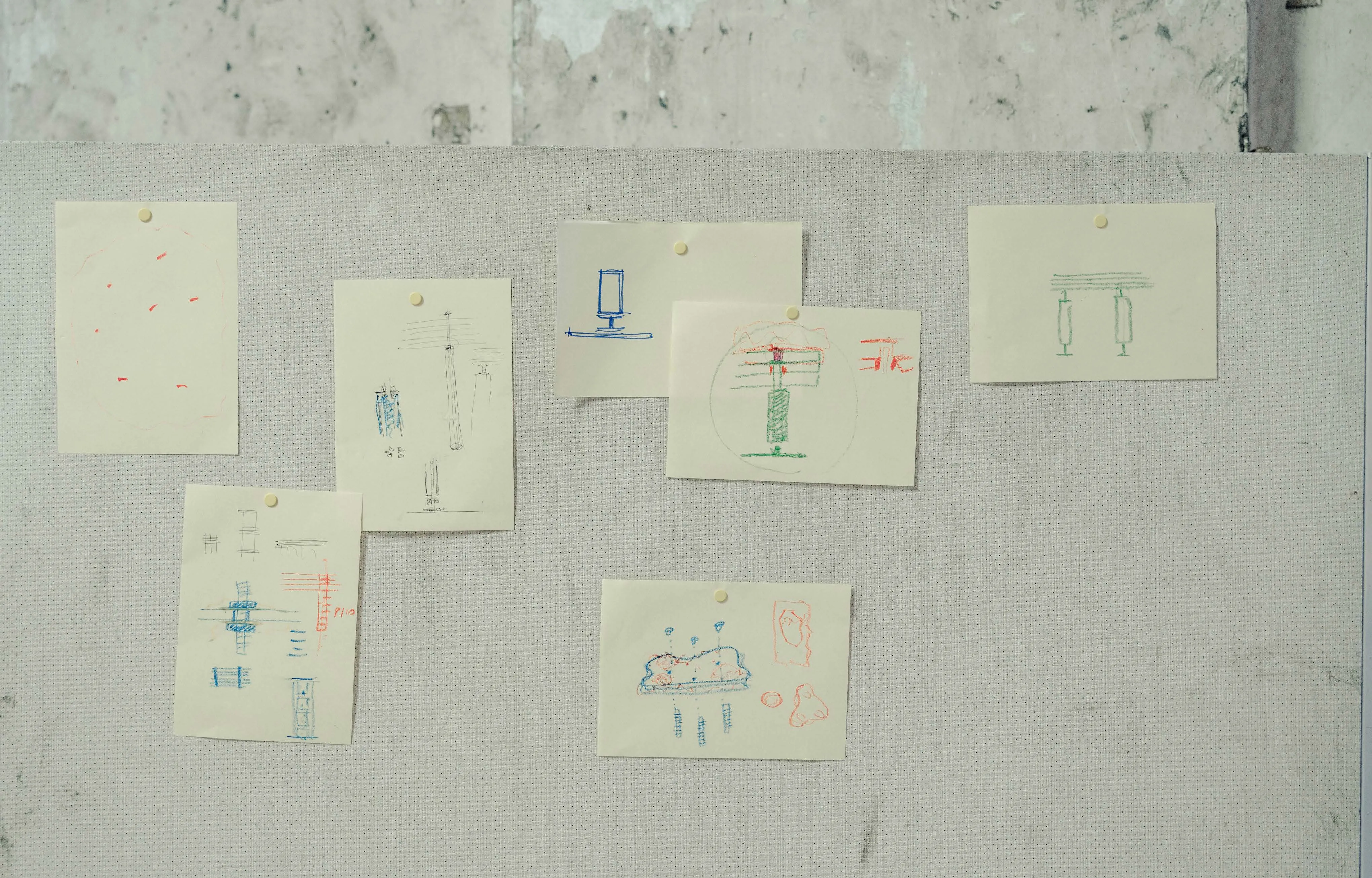 Schizzi e disegni di progetto appesi a parete in cantiere